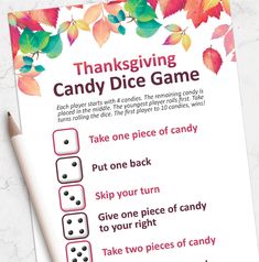 a thanksgiving candy dice game is shown on a table with a pen and paper next to it