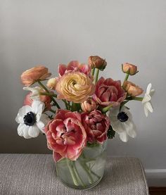 a vase filled with lots of flowers on top of a table