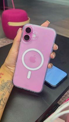 a person holding up a pink phone case with a magnifying glass on it