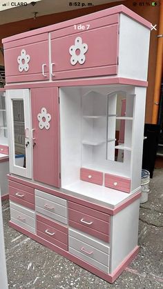 a pink and white dresser with drawers on it's sides is shown in front of other furniture