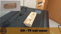 a tv mounted to the side of a wall next to a power cord and plugged in