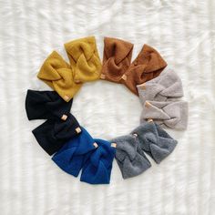 six different colors of hair bows arranged in a circle on a white furnishing