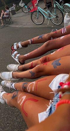 several people with painted legs sitting on the ground