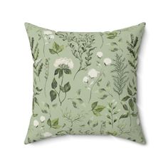 a green pillow with white flowers on it