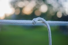 a close up view of a white wire with grass in the background