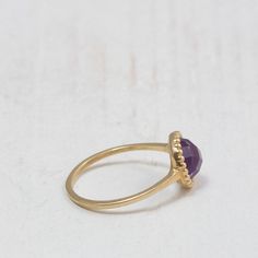 Purple Amethyst ring A dainty gold ring set at its center with a natural Amethyst gemstone. The stone is milgrain set with much attention to detail giving it an antiquated look. Handmade to perfection to bring out the purple beauty and clarity of this amethyst gemstone. Perfect for stacking with chevron rings. -Made to Order, perfectly finished, Fast shipping fully insured and trackable online. -Gemstone info: 7 mm Amethyst, Cabochon cut. -Ring width: 1.4 mm -Arrives gift ready with a certificat Elegant Amethyst Birthstone Crystal Ring, Elegant Amethyst Promise Ring, Dainty Amethyst Ring For Anniversary, Dainty 14k Gold Amethyst Ring, Delicate Amethyst Gemstone Ring For Anniversary, Elegant Amethyst Stackable Rings As Gift, Dainty Stackable Amethyst Ring For Anniversary, Minimalist Amethyst Birthstone Ring For Anniversary, Fine Jewelry Yellow Gold Amethyst Open Ring