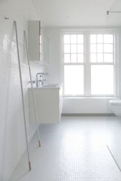 a bathroom with white walls and flooring next to a bathtub in the corner