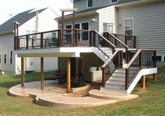 a deck with steps leading up to the upper level and an attached balcony above it