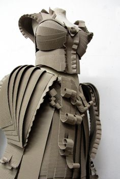 a sculpture made out of cardboard with multiple pieces of paper attached to the back of it