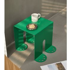 a small green table with a bowl on it