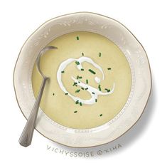 a bowl of soup with green sprinkles and a spoon on the side