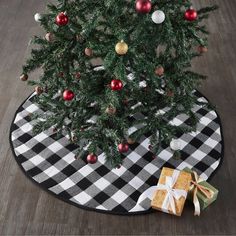 a black and white checkered christmas tree skirt with red, gold and silver ornaments