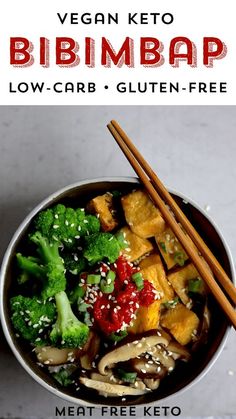 a bowl filled with broccoli, tofu and other vegetables next to chopsticks