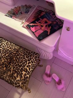 a leopard print chair sitting next to a white sink with pink accessories on top of it