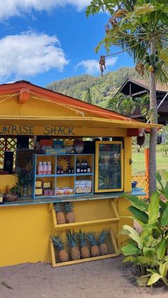 a small yellow shack with pineapples on display