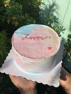 someone holding up a cake with the word love on it