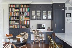 a kitchen with lots of bookshelves and chairs