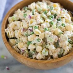 a wooden bowl filled with macaroni salad