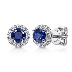 Deep blue sapphires sparkle within halos of stunning diamonds in these studs from Gabriel & Co.- 14K WHITE GOLD. - SAPPHIRE WEIGHT: 0.85 CTW. - DIAMOND WEIGHT: 0.18 CTW. - DIAMOND QUALITY: GH (NEAR COLORLESS) SI2 (SLIGHTLY INCLUDED).- 7.11 MM IN DIAMETER.- PUSH BACK.- Lusso Color Collection.- Can be ordered in different stone color.- Price may vary by color stone. Gia Certified Sapphire Diamond Earrings, Blue Sapphire Diamond Earrings With Halo Setting, Sapphire Diamond Earrings With Round Cut, Sapphire Diamond Round Cut Earrings, Sapphire Halo Diamond Earrings For Weddings, Sapphire Diamond Earrings With Halo Design For Wedding, Sapphire Halo Setting Round Cut Earrings, Brilliant Cut Sapphire Diamond Earrings, Sapphire Earrings With Halo Setting