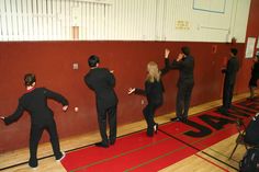 several people in black suits standing on a gym floor