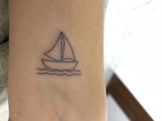 a small sailboat tattoo on the ankle