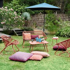 an outdoor area with lawn furniture and flowers in the back yard, including chairs and tables