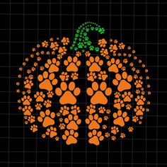 an orange pumpkin decorated with paw prints and a green letter on it's side