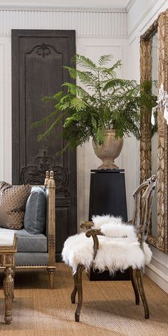 a living room filled with furniture and a plant in a vase on top of a table