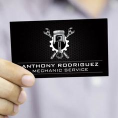 a man holding up a business card with an image of a wrench and spanner on it