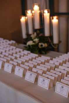 the table is set with place cards and candles