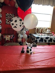 a table topped with lots of balloons and dalmatian themed decorations on top of it