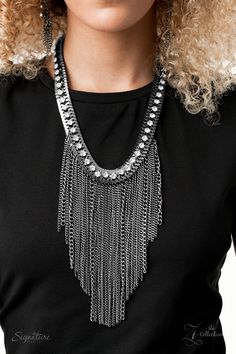 a woman with blonde hair wearing a black shirt and silver necklaces on her neck