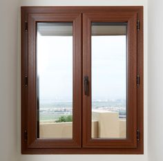 two wooden windows in a white room with a view of the city below them and outside