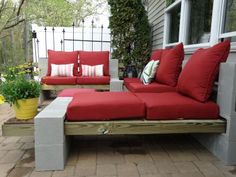 a red couch sitting on top of a wooden bench