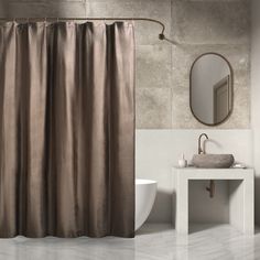 a bathroom with a sink, mirror and shower curtain in brown color on the wall