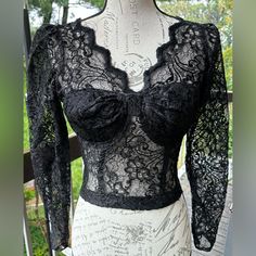 Lace & Embroidery Corset/Midriff Top Medium Like New / Never Worn Intricate Detail Exudes Romance With Its Scalloped Floral Corded Lace And Embroidery, A Flattering V-Neckline, And Plunging Open Back. * Lightly Padded Lace And Embroidered Bustier * Plunge Neckline With Deep “V” Open Back * Structured Corset Bodice * Long Lace Sleeves * Adjustable Hook & Eye Closure At Lower Back * Cropped Fit * 40% Rayon, 30% Acetate 30% Nylon * Hand Wash * Brand: Solana Measurements: About 16" From Shoulder To Hem Adjustable Waist: 24”-26” Cup Size: Approx. C-D Black Lace Tops For Party, Black Lace Party Tops, Fitted Long Sleeve Lace For Party, Black Lace Top With Lace Work, Black Lace Top For Party With Lace Work, Fitted Black Top For Wedding, Black Fitted Top For Wedding, Fitted Embroidered Lace For Party, Embroidered Fitted Lace For Party