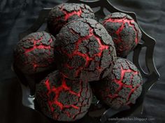 a bowl filled with black and red cookies on top of a table