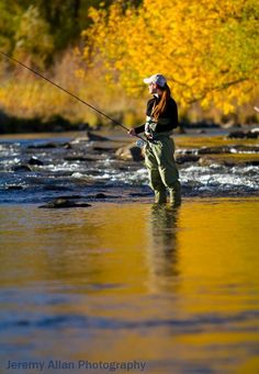 a man standing in the water while fishing