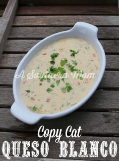 a white bowl filled with soup sitting on top of a wooden table