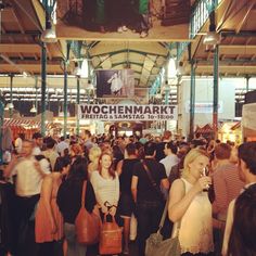 a crowd of people walking around a market