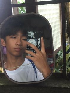 a young man taking a selfie in front of a mirror with his cell phone