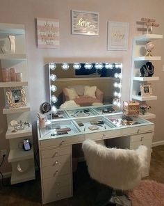 a vanity with lights on it and a chair in front of the mirror that is lit up