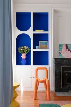 a living room with blue shelves and a fire place in the corner next to a fireplace