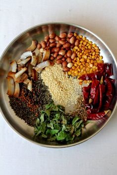 a metal plate topped with lots of different types of food on top of a white table