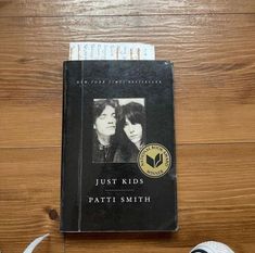 a book sitting on top of a wooden floor next to a pair of shoes