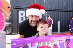 a man with a santa hat on holding a child