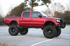 a red pick up truck parked in a parking lot