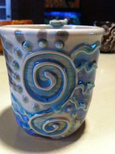 a blue and white cup sitting on top of a table