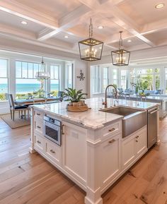 a large kitchen with an island in the middle and lots of windows on both sides