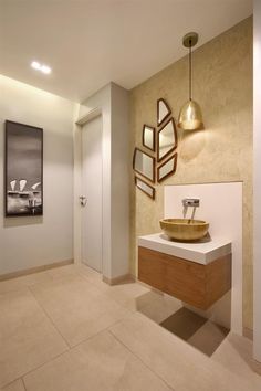 a bathroom with a sink, mirror and light fixture in it's center area